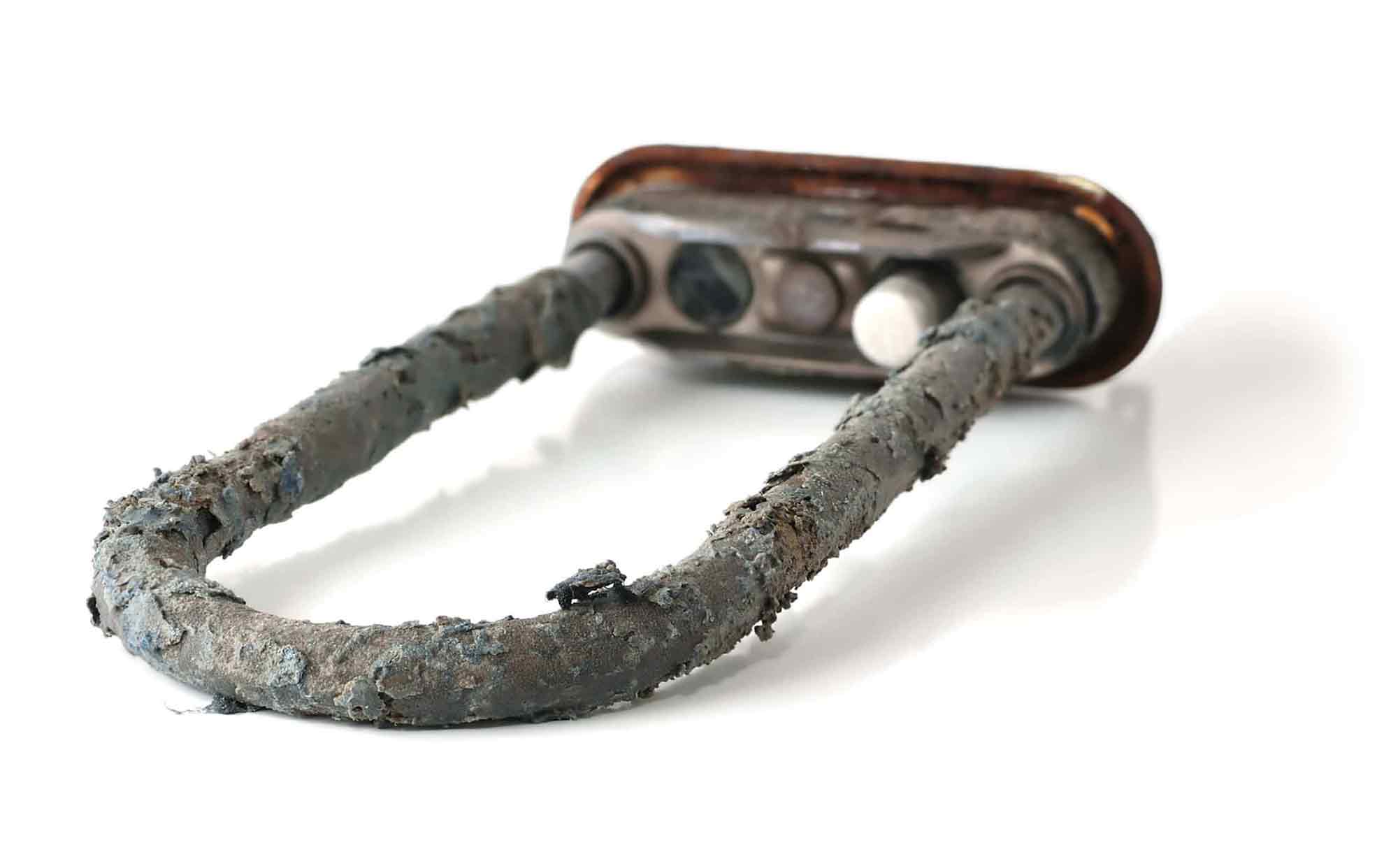 Поврежденный ТЭН кофемашины — сгоревший нагревательный элемент с критической накипью, требующий замены